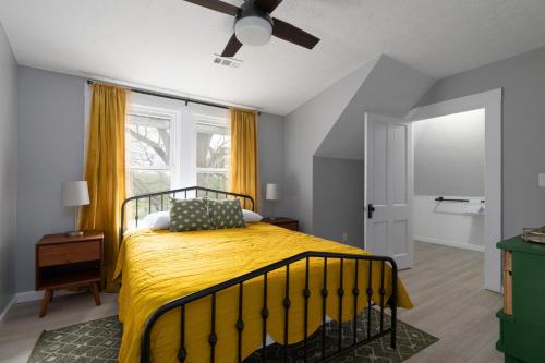 a bedroom with a bed with a yellow blanket at SAND HILL COTTAGE 3 Bedroom Home near PURDUE! River & Park View in West Lafayette