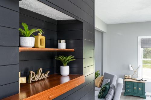 uma sala de estar com paredes pretas e uma prateleira com plantas em SAND HILL COTTAGE 3 Bedroom Home near PURDUE! River & Park View em West Lafayette
