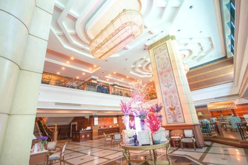 a lobby with a table with flowers on it at Golden Tulip Sovereign Hotel Bangkok in Bangkok