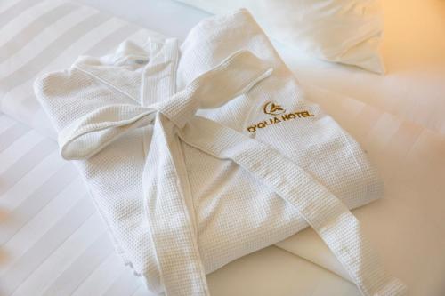a white towel with a bow on a bed at DQua Hotel in Nha Trang