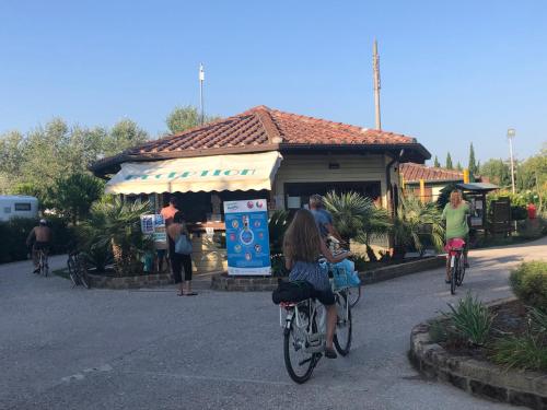 un gruppo di persone che vanno in bicicletta davanti a un carrello del cibo di Toskana, Viareggio,Chalet 27 mit Klimaanlage und Wlan a Viareggio