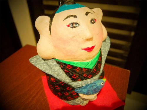 a figurine of a woman on a table at Guesthouse Bell Fushimi in Kyoto