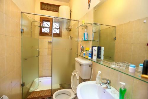 a bathroom with a toilet and a sink and a shower at Soho Greens Apartment 4 in Kampala
