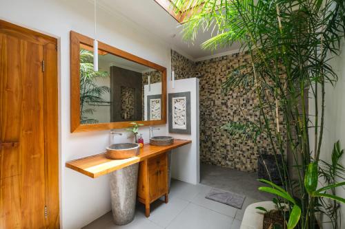 un bagno con lavandino e specchio di Molokai Suites a Uluwatu