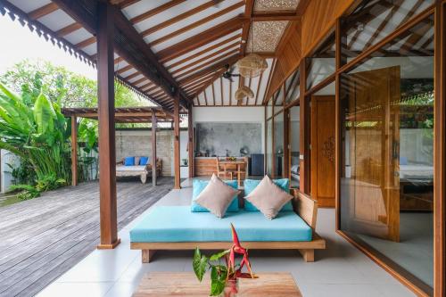 a patio with a blue bed on a wooden deck at Molokai Suites in Uluwatu