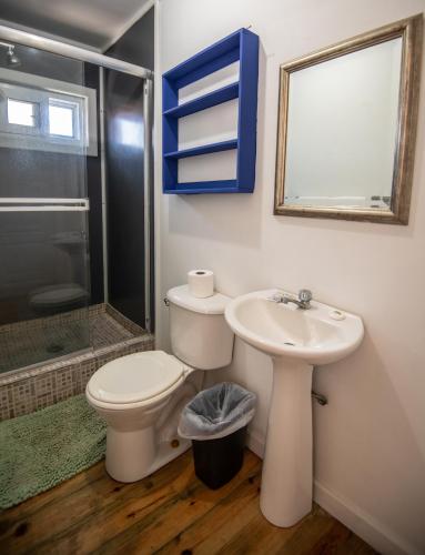 a bathroom with a toilet and a sink and a shower at Moon Apartments in Utila