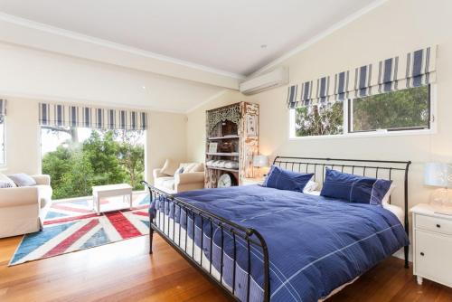 a bedroom with a bed and a living room at The Grove in Lorne