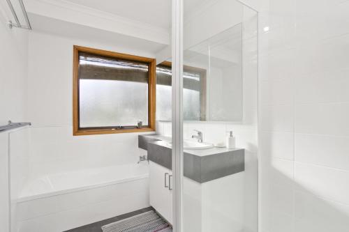 a white bathroom with a sink and a shower at Apollo Bay People N Paws in Apollo Bay