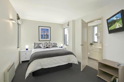 ローンにあるApartment 9 Kalimnaの白いベッドルーム(ベッド1台、バスルーム付)