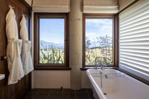 a bathroom with a tub and a window at Cabot Lodge - Fiordland National Park in Manapouri