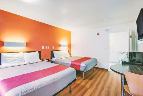 Habitación de hotel con 2 camas y escritorio en Key Inn Macedonia, en Macedonia