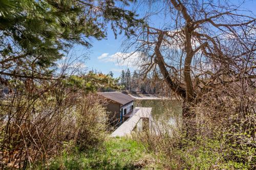 a small house on a dock on a body of water at The Wild Rose in Sagle