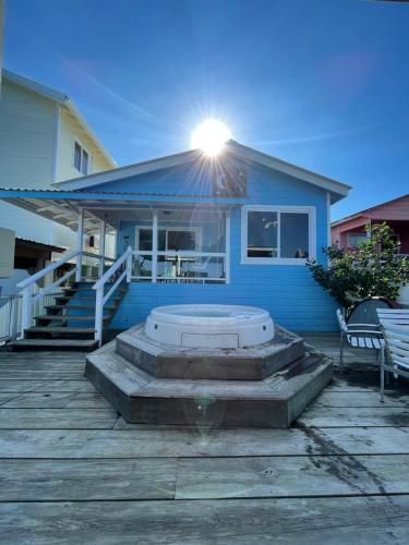 a blue house with a hot tub in front of it at Moon Apartments in Utila