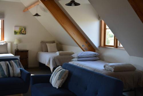 a attic room with two beds and a couch at DDOG Vineyard & BnB in Renwick