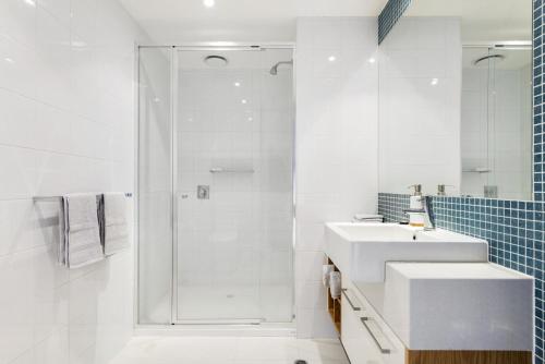 Un baño blanco con lavabo y ducha. en Apollo Blue 11, en Apollo Bay
