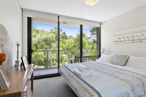 Un dormitorio con una cama y una ventana grande. en Lorne Chalet Apartment 42, en Lorne
