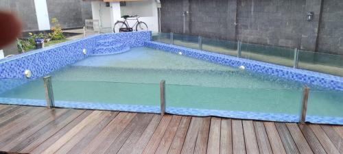 a large swimming pool with blue tiles on a wooden floor at Villa Azalea in Cireungit