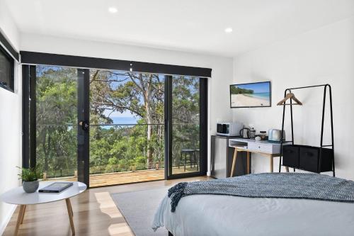 ein Schlafzimmer mit einem Bett und einem großen Fenster in der Unterkunft Lorne Hiatus in Lorne