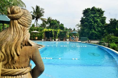 a statue of a woman looking at a swimming pool at Hotel Deli River and Restaurant Omlandia in Medan