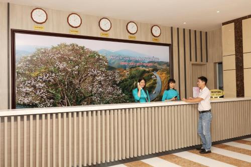 a man standing at a counter in a building at Khách Sạn Hoa Ban Trắng in Sơn La