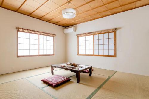 a living room with a table and two windows at Terrace Kyobate （Vacation house in Nara） in Nara