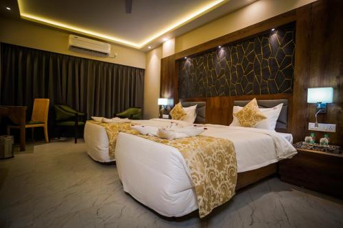 a hotel room with two beds with white sheets at The Adventure Luxury Hotels in Bhubaneshwar