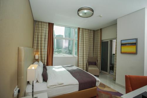 a hotel room with a bed and a window at OSKENA Vacation Homes - Damac Maison Cour Jardine in Dubai