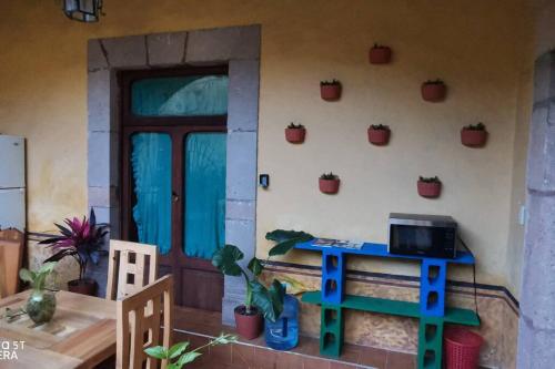 a room with a table and a door with potted plants on the wall at Lele Panchito y Lavanda Juntos en el Centro in Querétaro