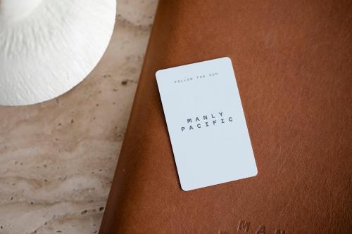 a white card sitting on top of a brown clipboard at Manly Pacific Sydney MGallery Collection in Sydney