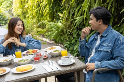 a man and woman sitting at a table eating food at Satoria Hotel Yogyakarta - CHSE Certified in Yogyakarta