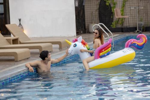 a man and a woman riding a unicorn in a swimming pool at Satoria Hotel Yogyakarta - CHSE Certified in Yogyakarta