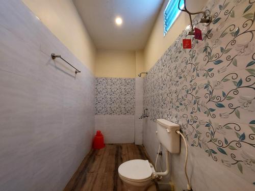 a bathroom with a toilet and a wall at Mohana Beach Resorts Mandarmani in Mandarmoni