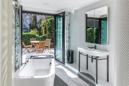 een badkamer met een bad en een wastafel en een patio bij Luxury Apartment Berlin Mitte in Berlijn