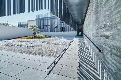 a hallway of a building with a tree in it at MUNI KYOTO by Onko Chishin in Kyoto