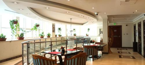 um restaurante com mesas e cadeiras num edifício em Musherib Hotel em Doha
