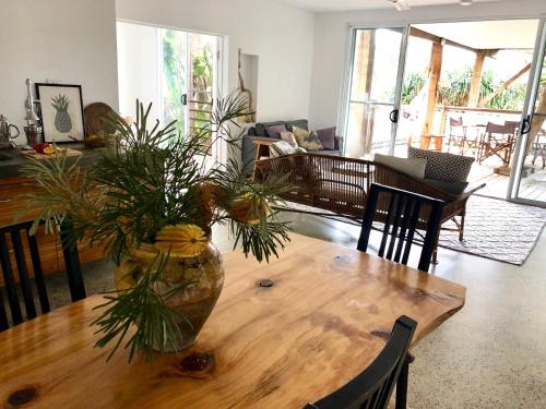 a living room with a wooden table with a vase on it at THE BEACH HAVENS - Haven Tropicana in Emerald Beach