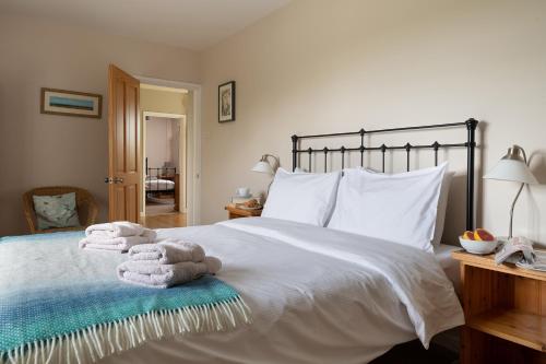 1 dormitorio con 1 cama con toallas en Chase Lodge, Kenilworth, Family Sized Cottage With free Wifi en Kenilworth
