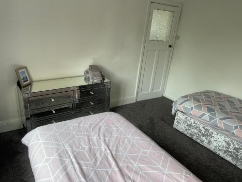 a bedroom with a bed and a dresser next to a bed sidx sidx sidx at No 6 Chestnut Grove in Withernsea