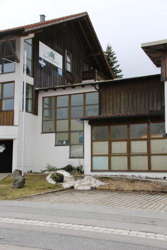 a white building with a wooden roof at Apartements 270-275 Mitterdorf in Mitterfirmiansreut
