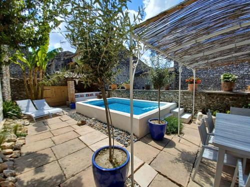 een zwembad in een tuin met een pergola en een boom bij Chez les filles in Dions