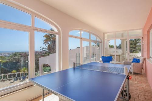 a blue ping pong table in a room with windows at Casa Monte Cristo Tres in Lagos