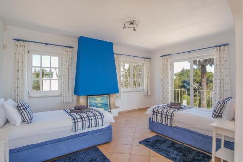 a blue and white bedroom with two beds and windows at Casa Monte Cristo Tres in Lagos