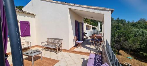 a balcony of a house with a table and chairs at Belvedere de Canaloro in Sari Solenzara