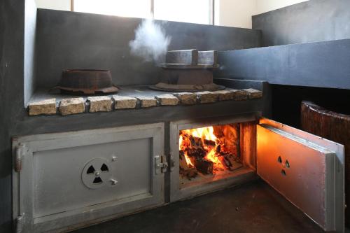 a kitchen with a stove with a fire in it at 古民家ー芦ヶ久保 in Chichibu