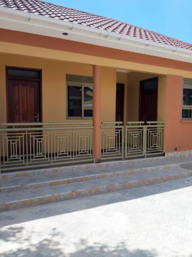 a building with a balcony and stairs on it at Candle Wood Homes in Lira