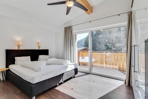 a bedroom with a bed and a large window at STANTON Lodge in Sankt Anton am Arlberg