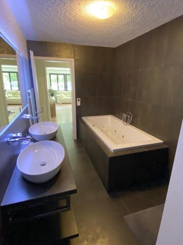 a bathroom with a large tub and a sink and a bath tub at Amazing appartment in the middle of the nature in Silenen