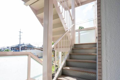 a staircase leading up to a building with a window at it senriyama 203 in Senriyama