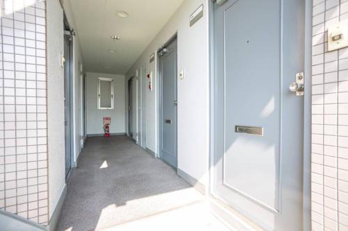 a corridor of a hallway with white walls and doors at it senriyama 203 in Senriyama