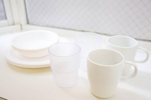 a group of white cups and plates on a counter at it senriyama 203 in Senriyama